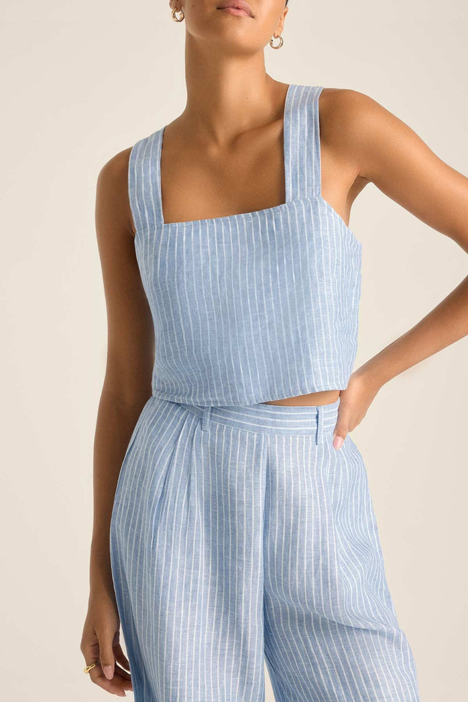 Woman wearing a blue and white striped beach tank top with matching pants
