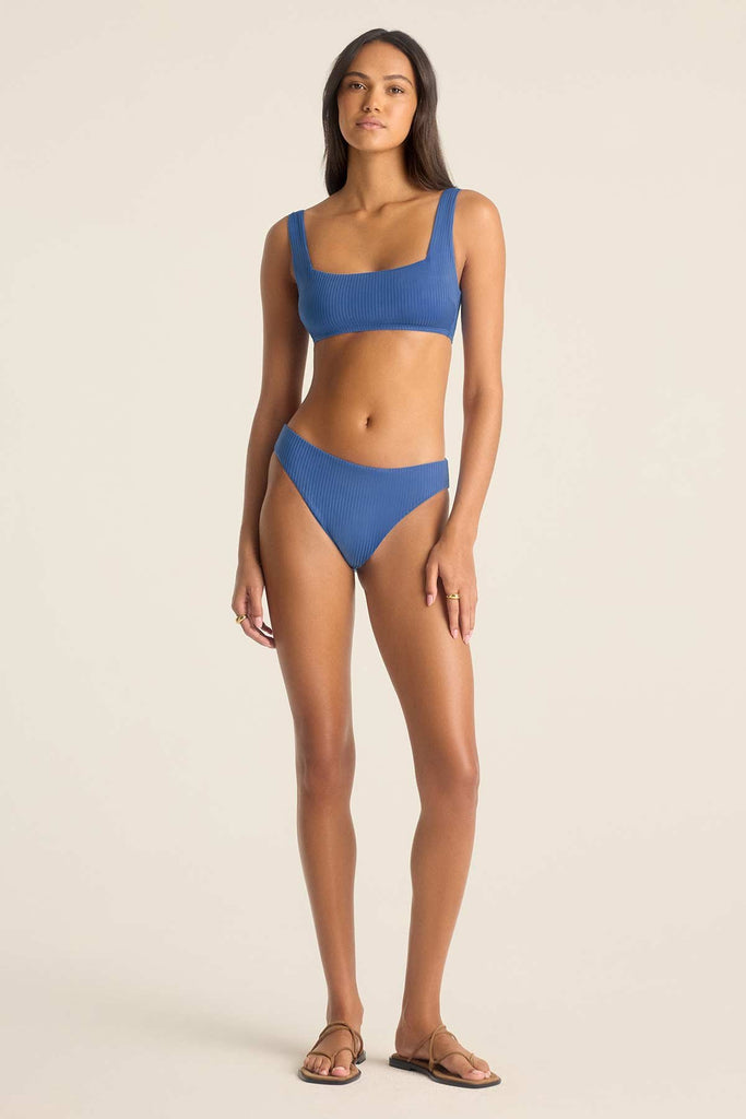 Woman wearing a blue swim top with matching swim bottoms