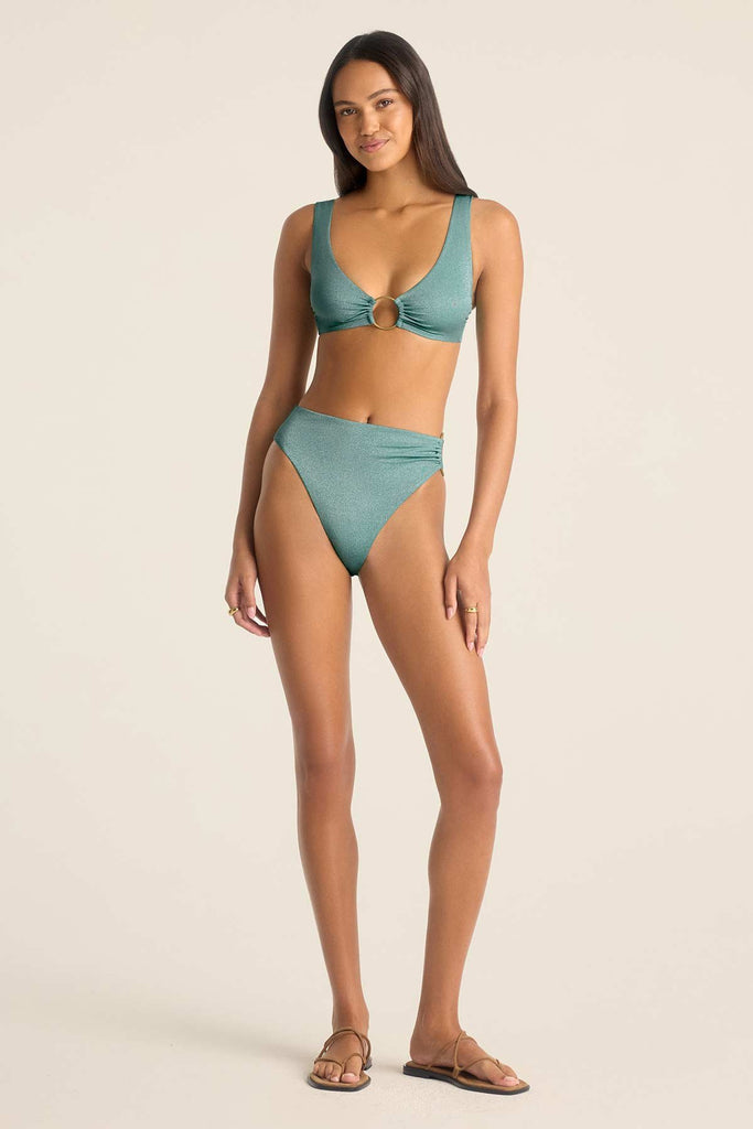 Woman wearing a O ring detail metallic aqua swim top with matching swim bottoms