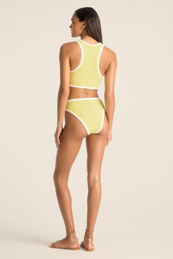 Woman turned away wearing a yellow high neck swim top with matching swim bottoms and white trim
