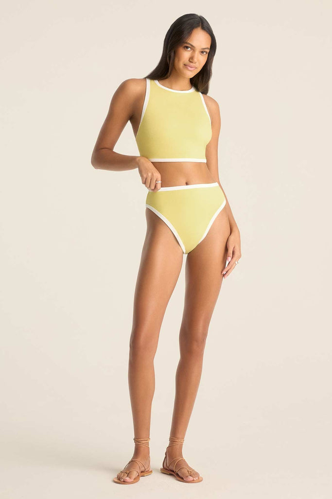 Woman wearing a yellow high neck swim top with matching swim bottoms and white trim