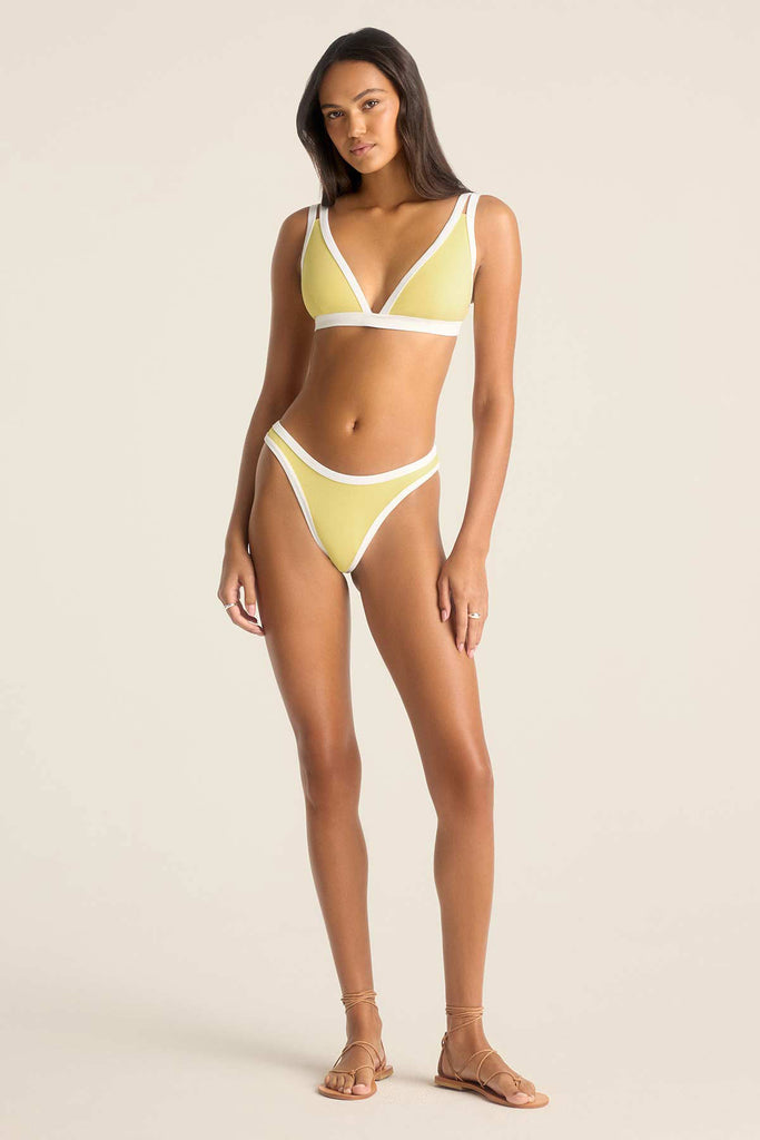 Woman wearing a yellow bikini top with white trim and matching swim bottoms