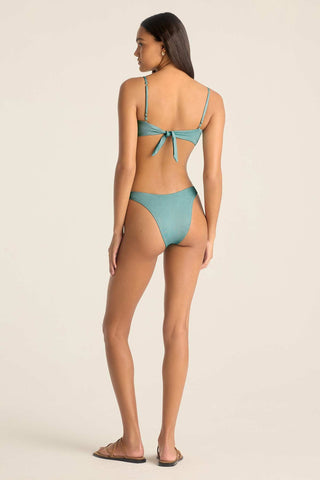 Woman turned away wearing a metallic aqua swim top with matching swim bottoms
