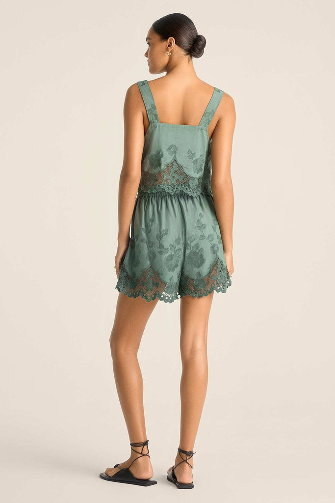 Woman turned away wearing a sea green lacy beach tank top with matching shorts 