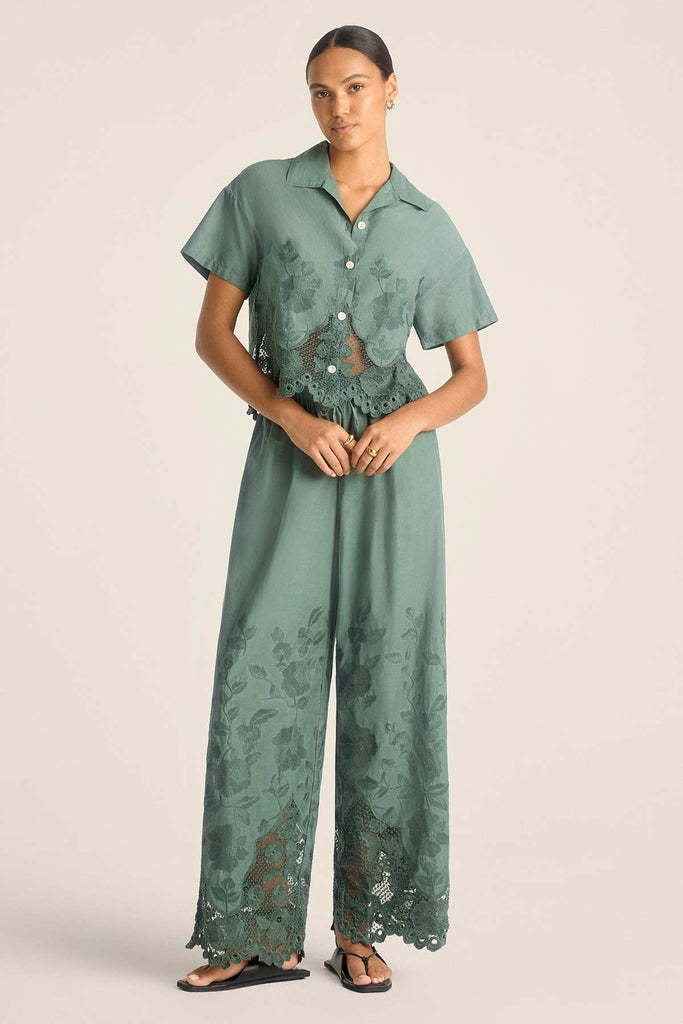 Woman wearing a sea green lacy beach shirt with matching pants
