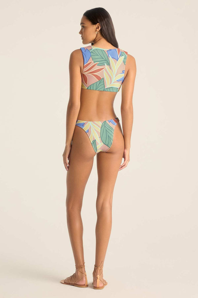 Woman turned away wearing a jungle printed bikini top with matching swim bottoms