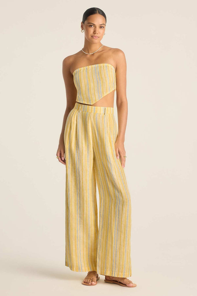 Woman wearing a scarf top with yellow and blue stripes with matching pants