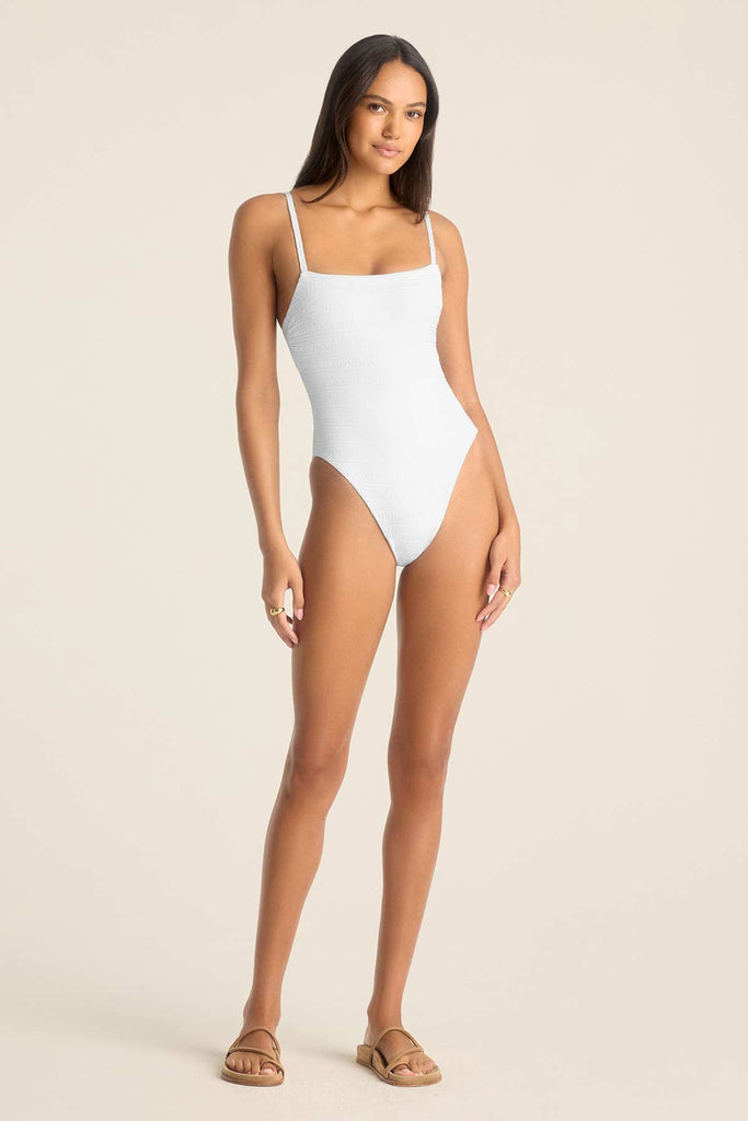 Woman wearing a white one-piece swimsuit