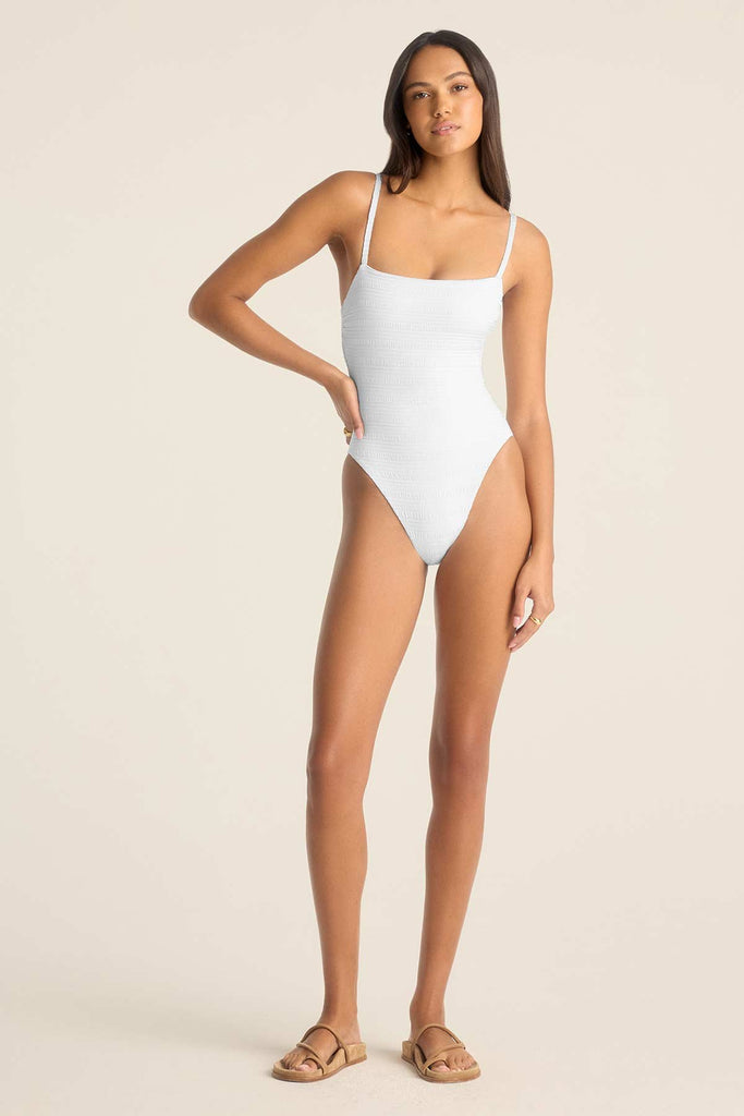 Woman wearing a white one-piece swimsuit