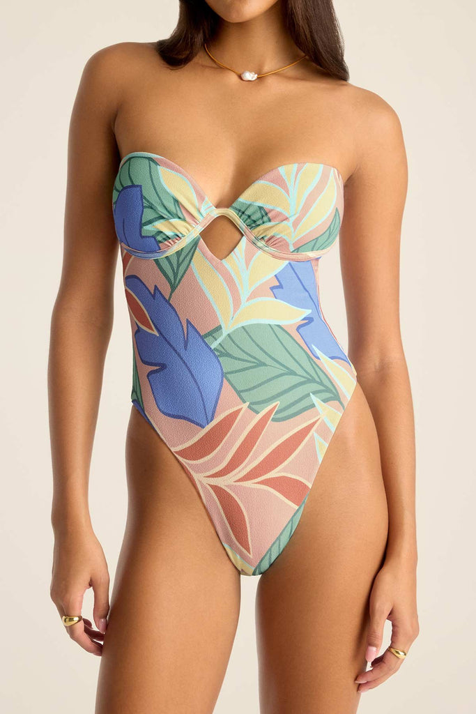 Woman wearing a bandeau one-piece jungle printed swimsuit with a close up of the detail
