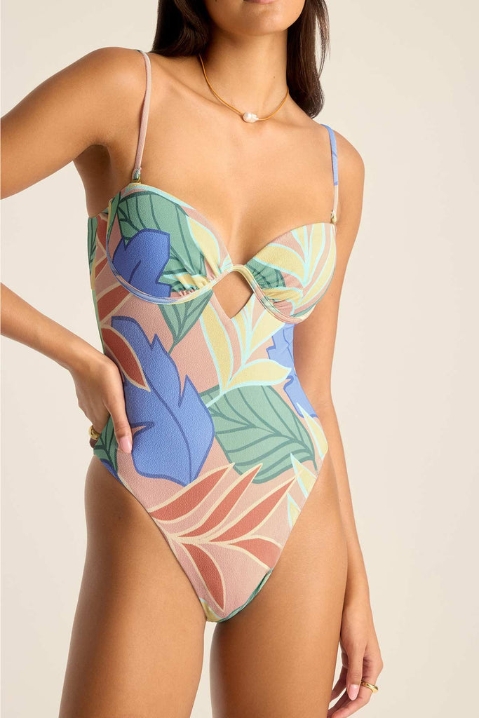 Woman wearing a bandeau one-piece jungle printed swimsuit with straps and a close up of detail